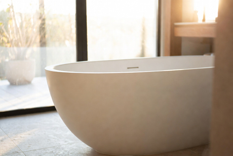 White Resin Stone Bathtub In Sunlit Bathroom.jpg